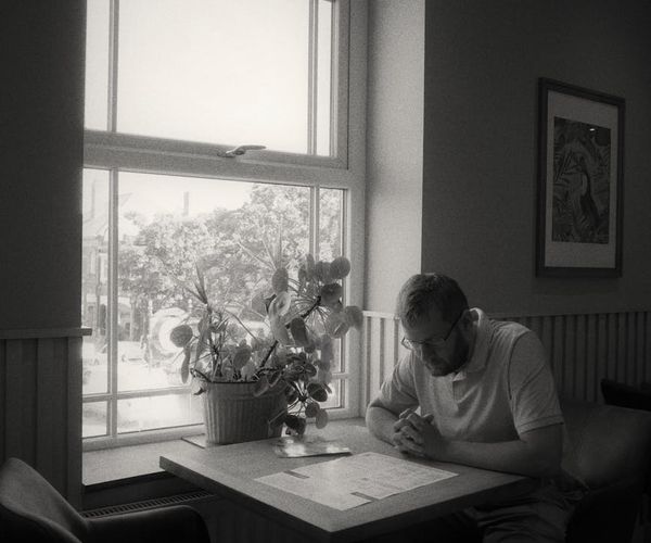 A person in a calm, focused state in a minimalist bright room.